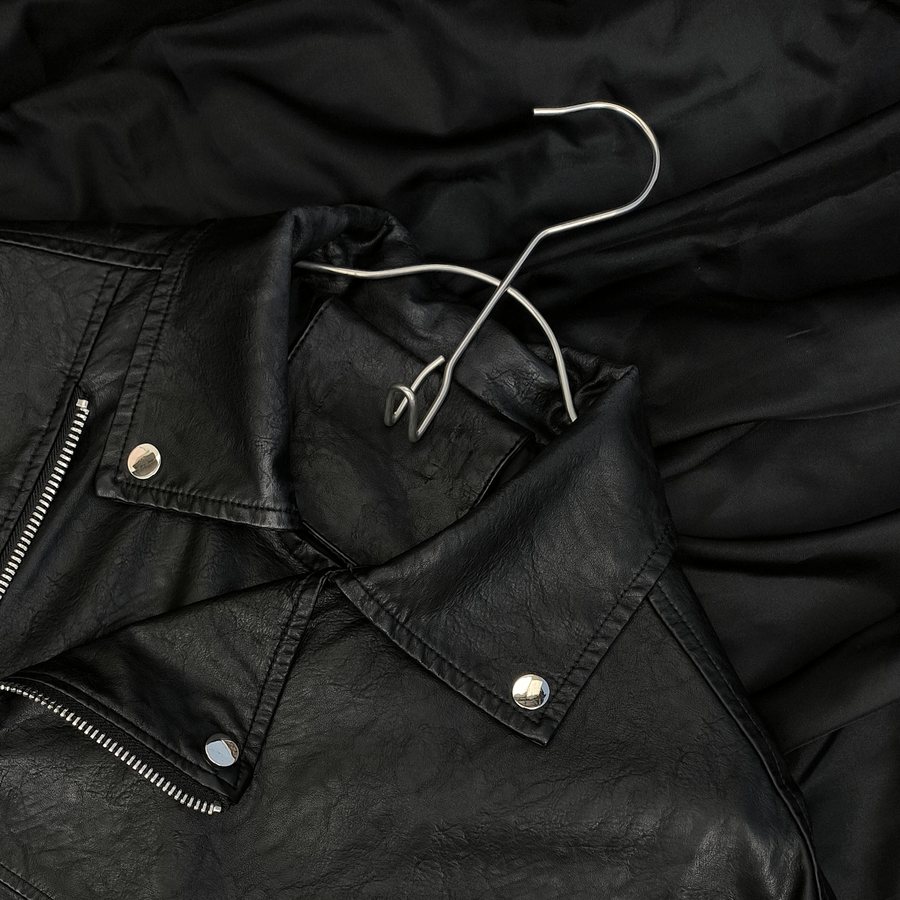 Close view of a collar, snap studs and a zip.